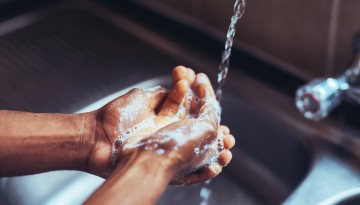 Washing hands under faucet