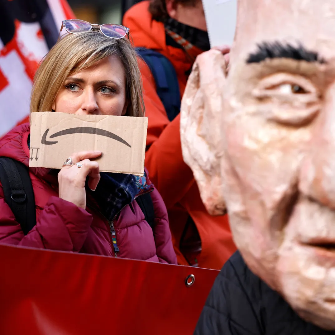 Woman holds Amazon packaging in front of her face during protest