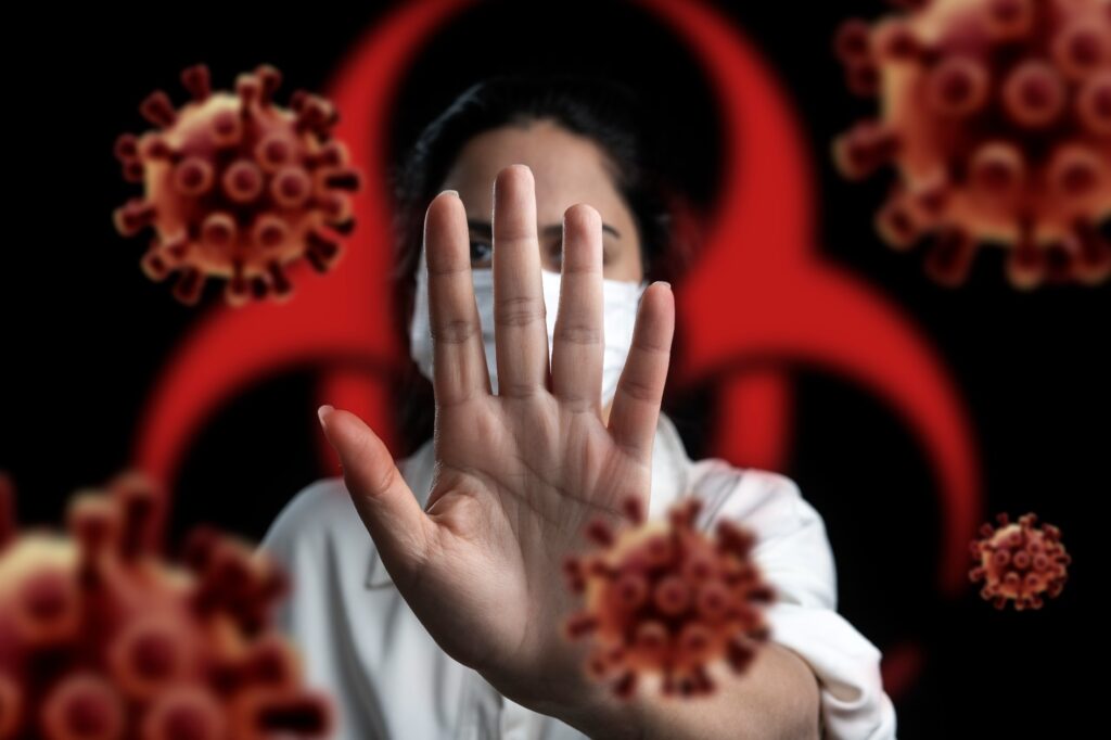 Health professional holds out hand to keep virus away