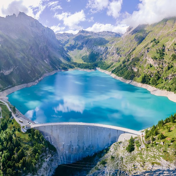 Water dam and reservoir lake in Swiss Alps mountains