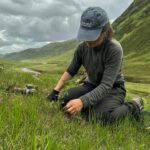 Hannah Kirkland working in a field in a valley