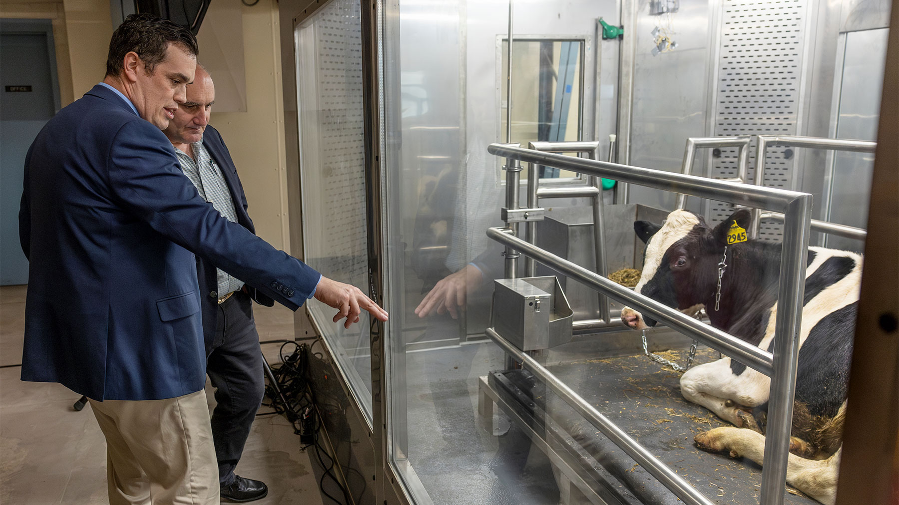 RESPIRATION CHAMBER: Joe McFadden, associate professor of dairy cattle biology and animal science at Cornell University, talks about the climate-controlled respiration chambers with a visitor during a recent ribbon-cutting for the $2 million project. Photos courtesy of Cornell University