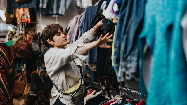 Adobe Stock - woman looks at clothes on the rack