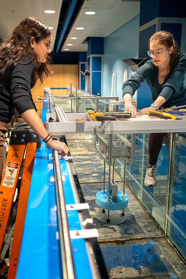 Kavya Mittha ’26, left, and Aisha Brundan ’25 prepare to submerge and test their bobbing buoy wave energy converter at the DeFrees Hydraulics Lab.