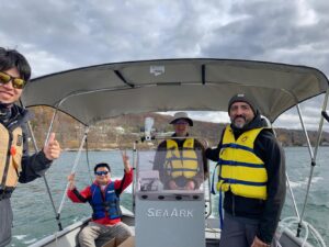 Todd Cowen, Jose Andres, and student researchers in motorboat on Cayuga Lake