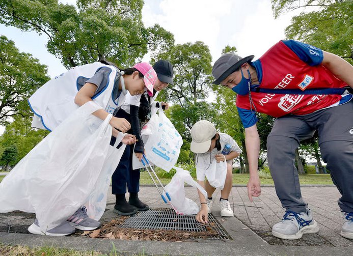 Participants gather trash during SPOGOMI World Cup in Tokyo last year. Teams of players from around the world competed for points awarded according to the amount and type of trash picked up. (The Yomiuri Shimbun via AP)