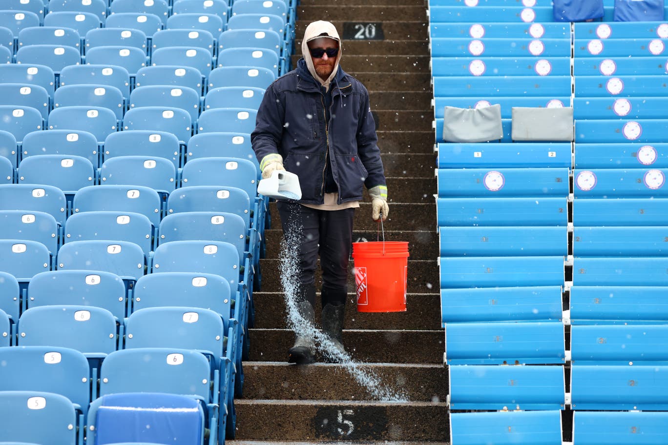 Salt is applied to the steps as snow falls at Buffalo Bills Highmark Stadium before an NFL football game between the Buffalo Bills and the Cincinnati Bengals, Dec. 7, 2025, in Orchard Park, N.Y. (AP Photo/Jeffrey T. Barnes, File)