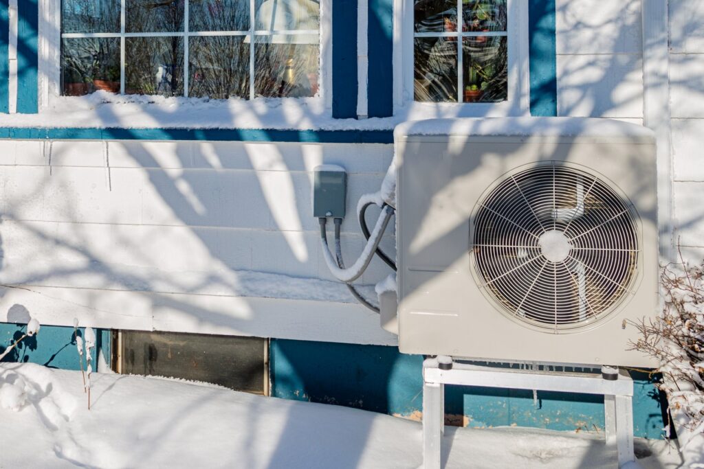 Electric heatpump on the side of a house during winter