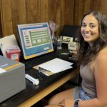 Allassandra Valdez at a computer, connected to scientific instruments